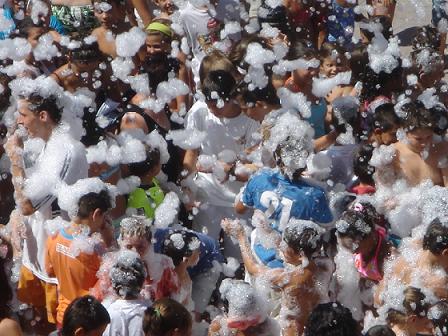 La Fiesta de la espuma congrega en la Plaza de España a varios cientos de niños y jóvenes